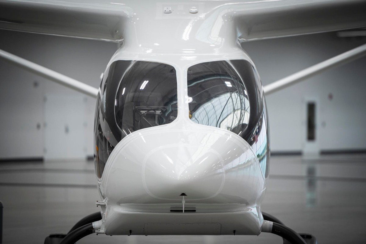 A small white airplane parked in a hangar.