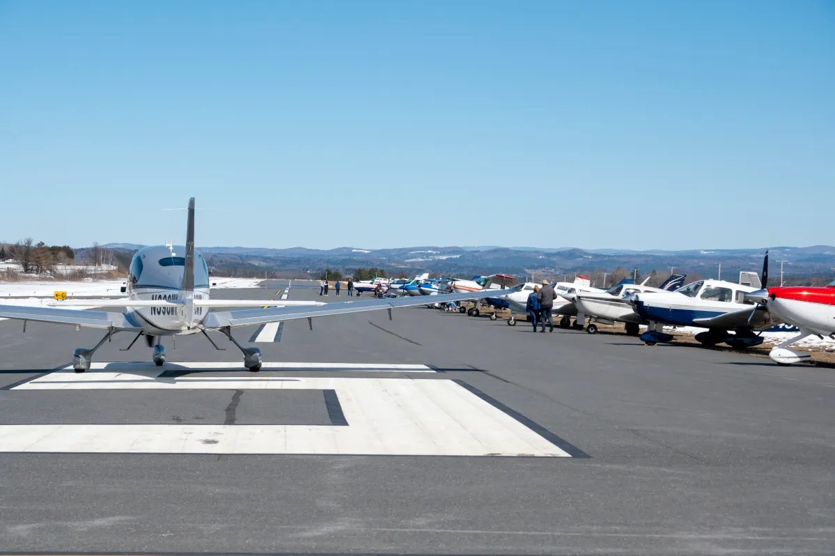 Planes on a runway under blue skies.