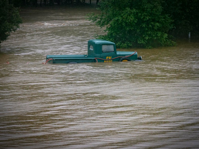 a green truck in a flooded river.
