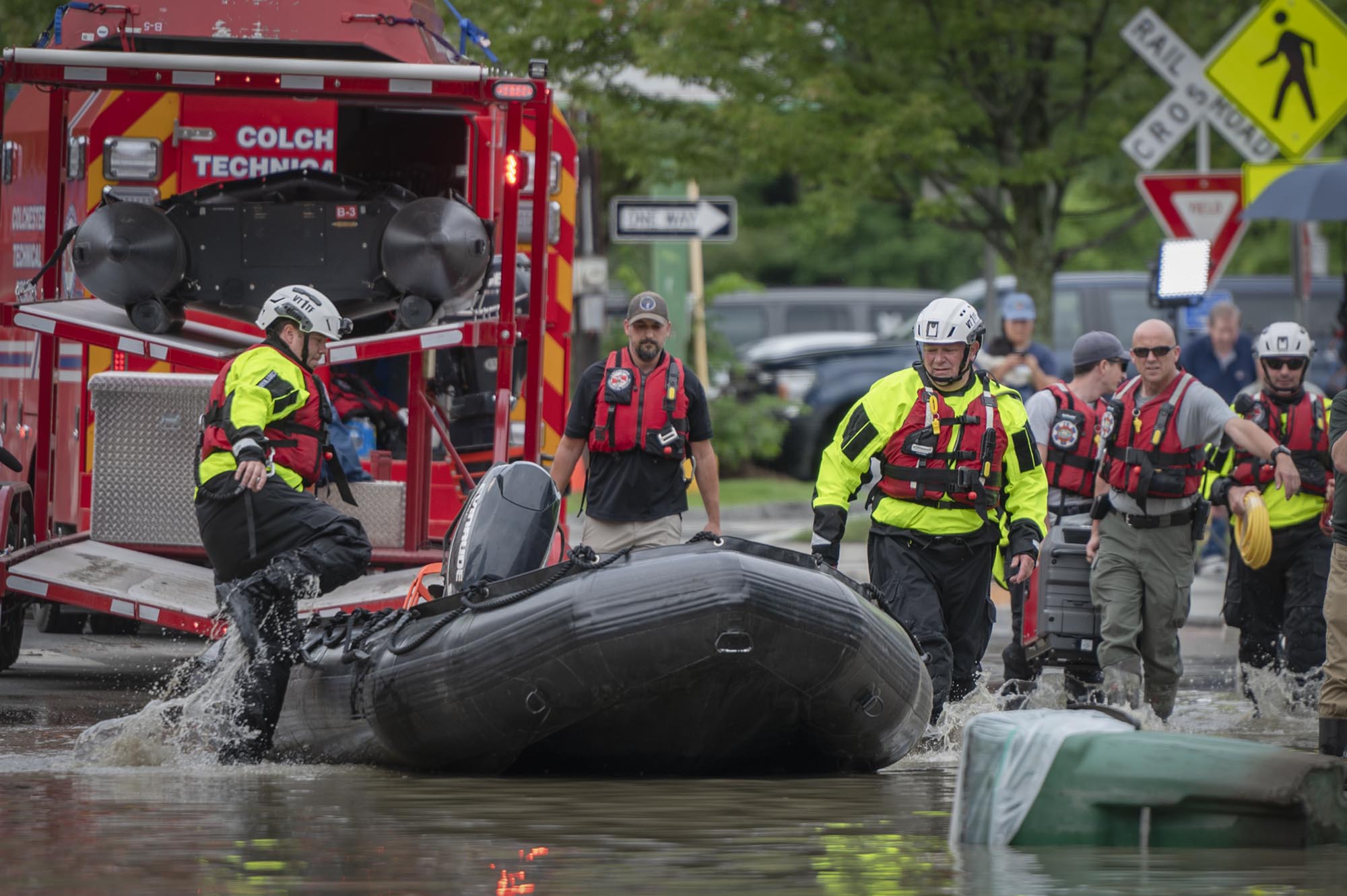 a group of people standing on a boat in a flooded street.