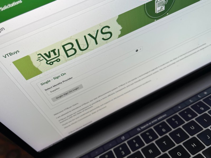 A close-up of a laptop screen displaying the VTBuys login page for single sign-on, with a green header and login options.